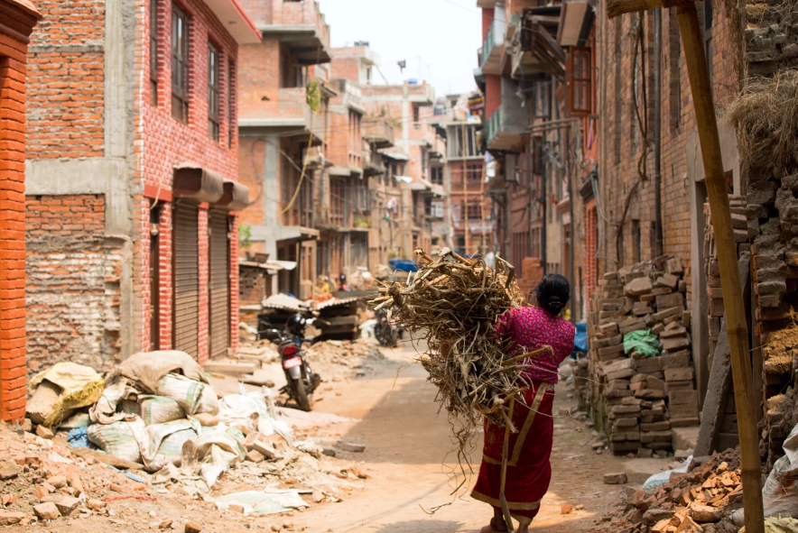 An old Nepalese Lady carrying wood for cooking and warmth.